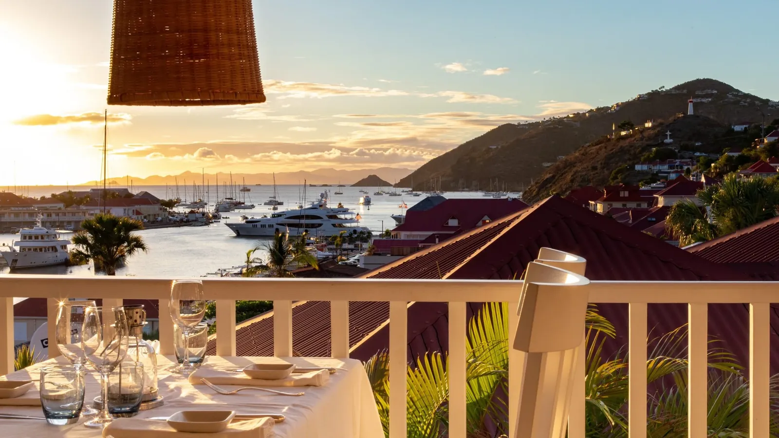 Dinner table on a balcony above Gustavia harbour at sunset, Saint-Barthélemy