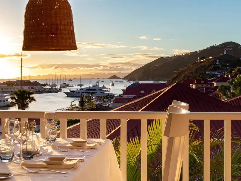 Dinner table on a balcony above Gustavia harbour at sunset, Saint-Barthélemy